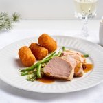 Op het bord liggen enkele sneetjes van het varkenshaasje, perfect roze zoals het moet. Wij serveren het met kroketten en boontjes, een heerlijk eenvoudig feestgerecht dat iedereen kan bekoren.