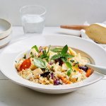 Een diep wit bord is gevuld met de salade op basis van Belgische quinoa, groenten en Damse Mokke. Het resultaat is heerlijk kleurrijk, waardoor je meteen aan de slag wil gaan!