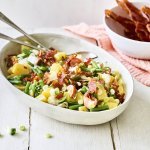 Een heerlijke salade staat te schitteren op tafel, klaar om te eten. De kleuren zijn prachtig, groene van de boontjes, goud van de aardappel en afwerken doen we met krokante hamsnippers en toefjes van het sausje.