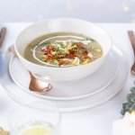 Een heerlijk kommetje witloofsoep staat op de feesttafel. De soep is afgewerkt met een lepel room, witloofsnippers en krokante ham.